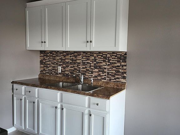 Kitchen with new cabinets, new sink, new backsplash, new light fixtures.