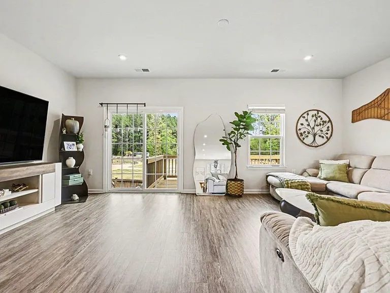 Large living room space which opens directly to the kitchen and access to the deck