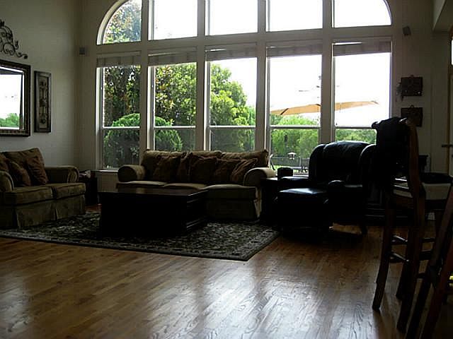Open Family Room with Views of the Golf Course Includes a Builtin Entertainment Cabinet & a Fireplace with Gas Logs