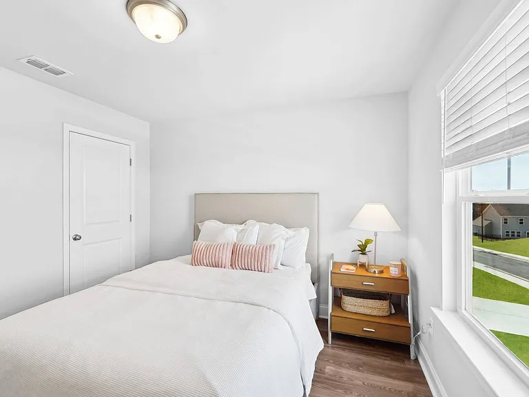 Secondary bedroom with queen size bed and large window letting in a ton of natural light.