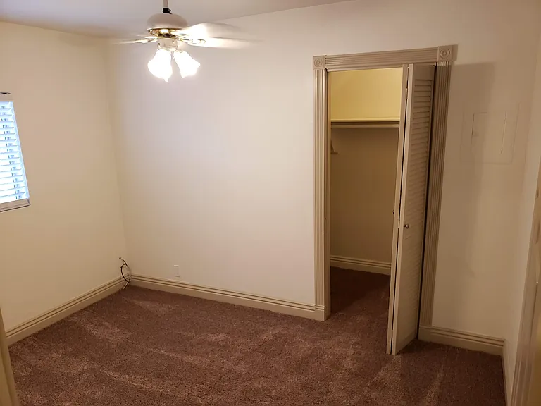 Second bedroom and closet. Note the ceiling fan.