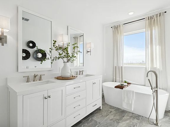 Primary bath featuring freestanding vanity with dual sinks