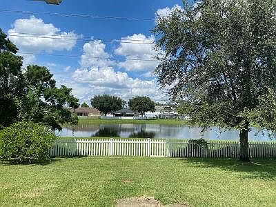 Back yar with a picket fence and gate to the pond