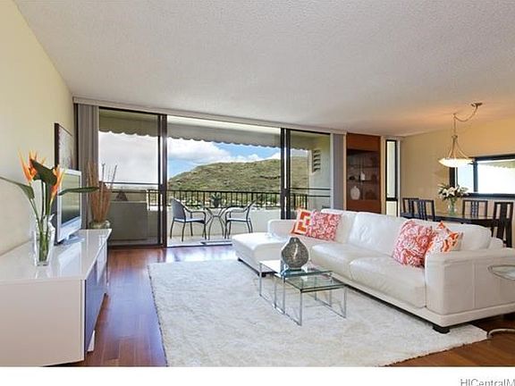 The spacious, bright and airy living room features hardwood flooring and high ceilings.