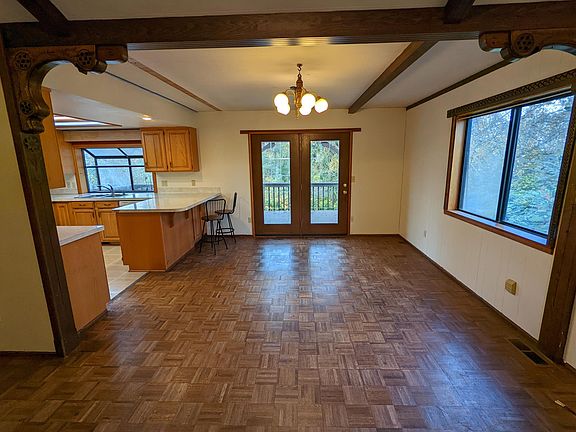 Dining Room with kitchen to the left and back deck through french doors