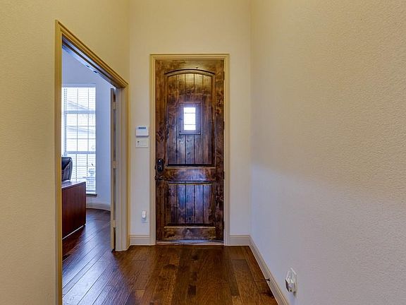 Beautiful entrance with rich wood floors and barrel ceiling, and office to the left