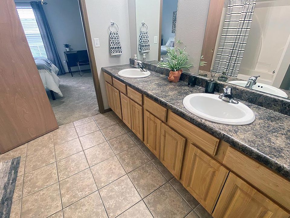 Bathrooms featuring granite-style countertops, large mirrors and ample cabinetry for your storage needs.