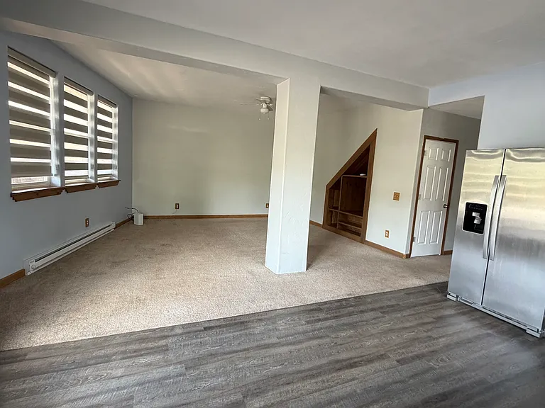 Kitchen to dining/living area, built in storage, plenty of natural light, shades drawn
