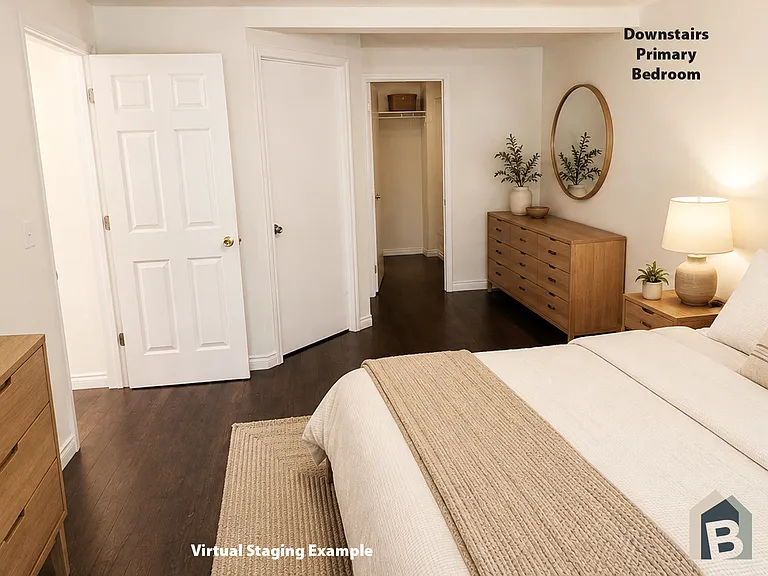 1st floor primary en-suite with large walk-in closet and view of lawn and mature evergreen trees