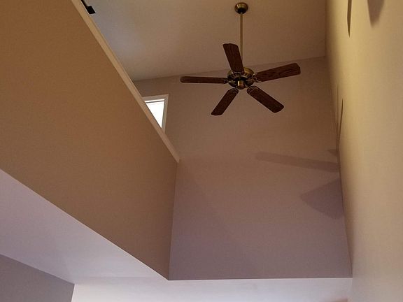 First floor, standing near stairs, viewing up to open area. Great air circulation with two large ceiling fans.