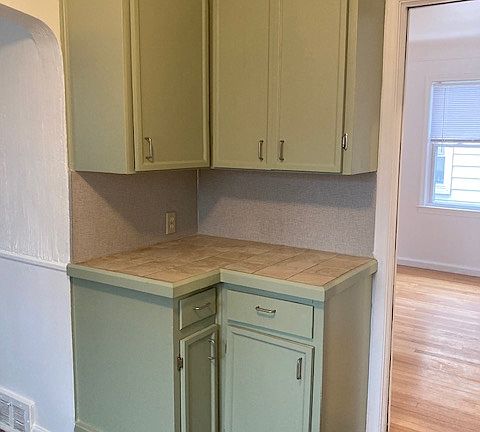 Kitchen corner cabinets with ceramic tile counter.