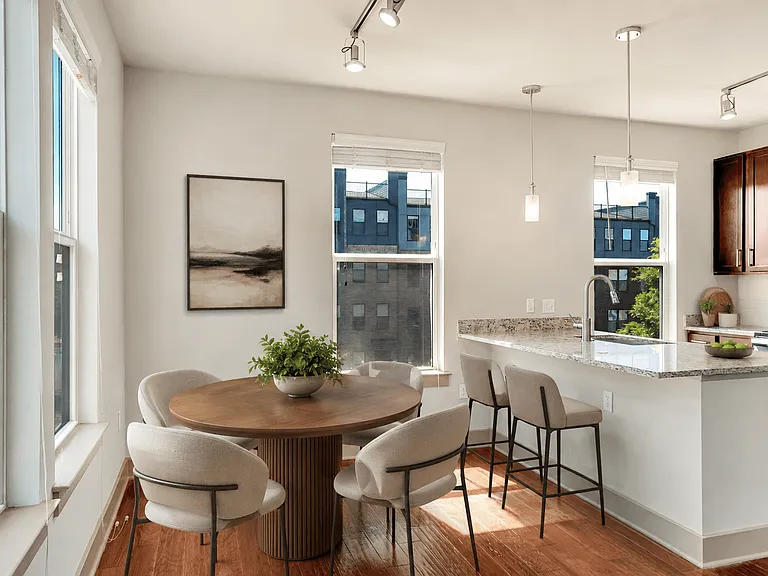 A modern kitchen with a dining table and chairs.