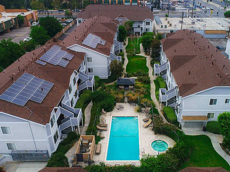 Aerial view of the courtyard, pool, jacuzzi, and solar panels.