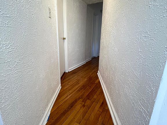 Hallway leading away from living room towards the main bathroom, bedroom #2 and kitchen.