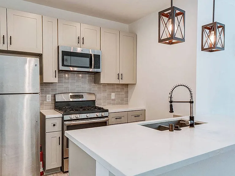 Kitchen with new modern styled faucet, stainless steel appliances, and refrigerator.
