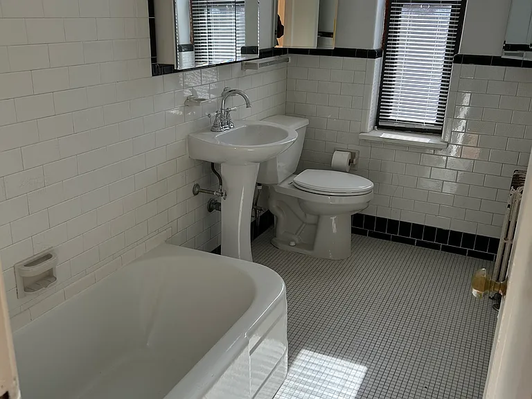 Vintage bathroom with updated pedestool sink and reglazed tub.