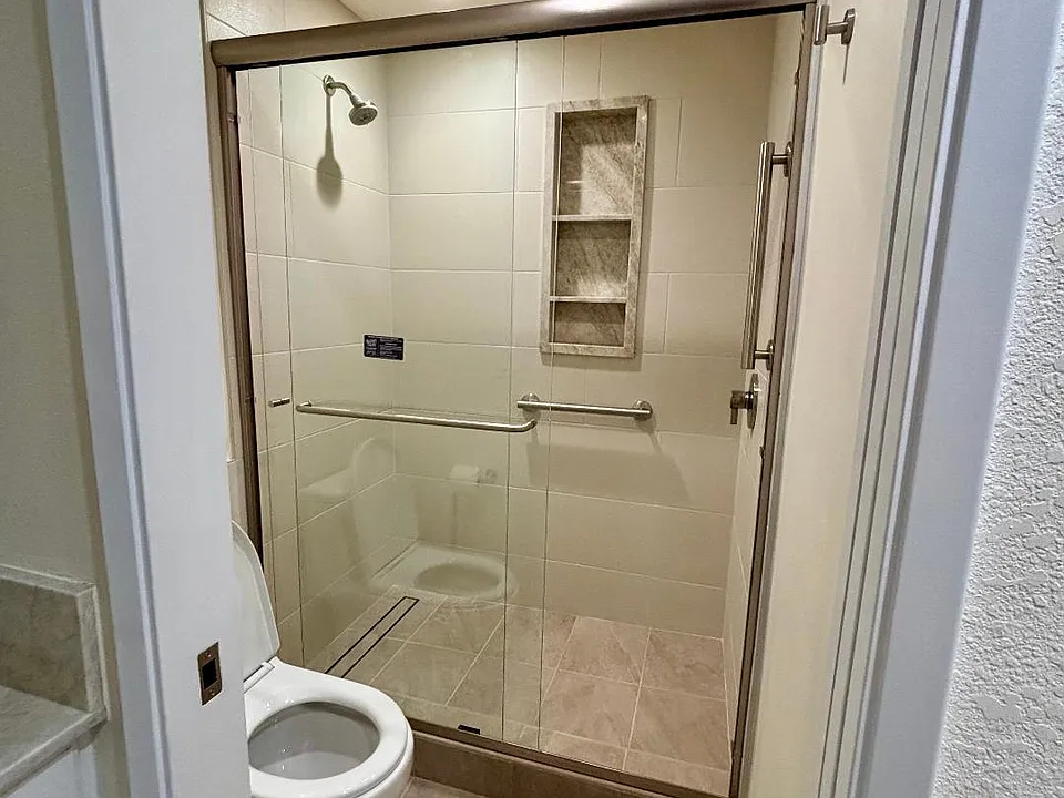 bathroom with walk in shower and grab bars