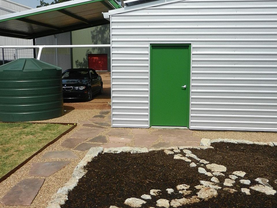 This looks west from the back deck to the herb garden and garden shed, which is shared storage space for the residents. The carport and shed hold the solar array and rainwater is collected for the landscape.