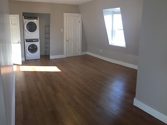 Living room looking to front door and laundry in closet.