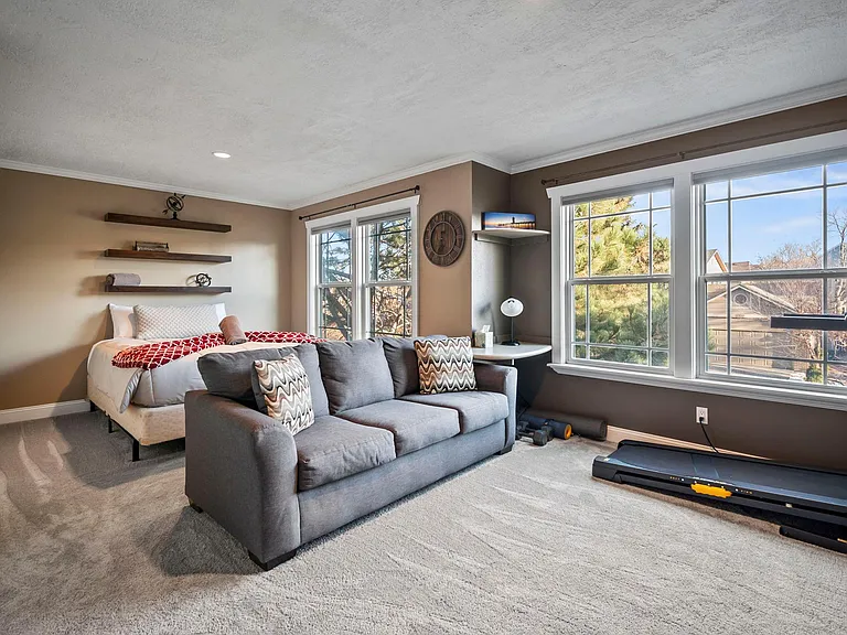 One of the upstairs secondary bedrooms- perfect for accommodating children or additional guests. Equipped with a flex space to enjoy a workout on the treadmill or all of your favorite shows on the flat screen.