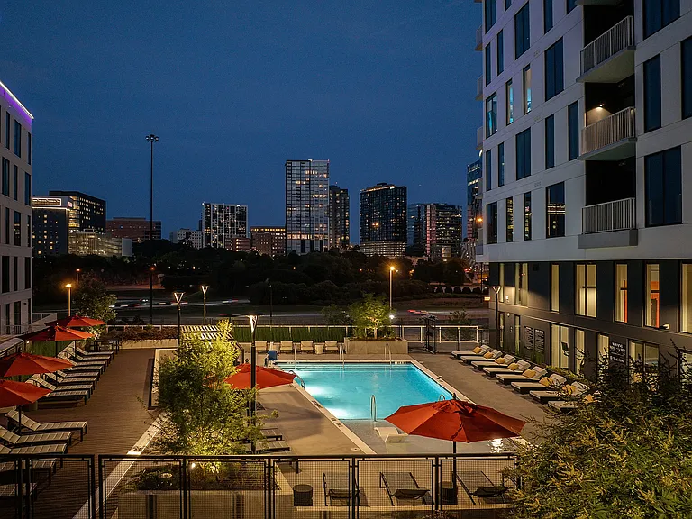 Swimming pool and cabana seating with skyline views