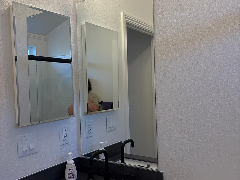 Bathroom sink has storage below plus a medicine cabinet to the left