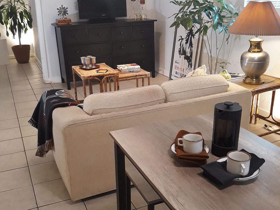 View of living\TV area, cafe kitchen table in foreground, easy-care ceramic tile floors