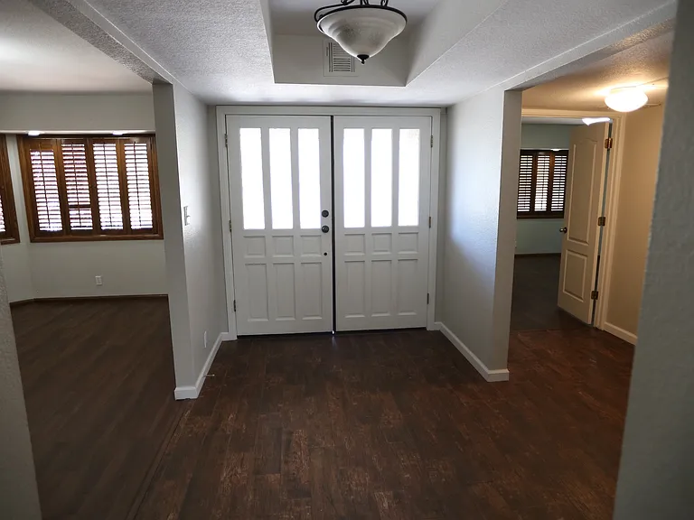 front door and view to primary suite 1 on the right and formal living room/office/extra living space on the left