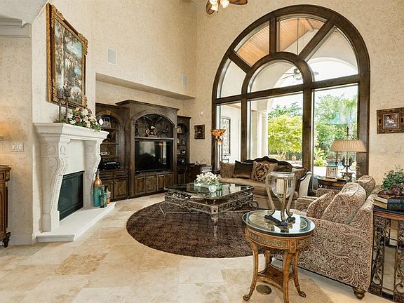 Living area with 20' ceilings, picturesque window, cast stone fireplace and built-ins
