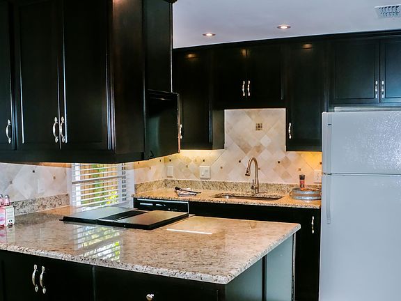 Remodeled kitchen with an abundant of new expresso wood cabinets and granite counter tops.