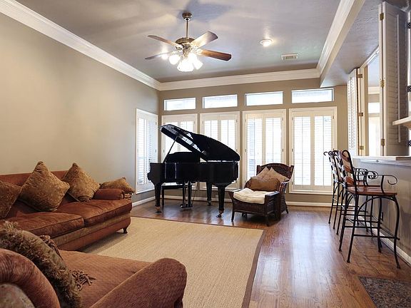 View of living room & transom windows looking out to back yard. Breakfast/entertaining bar is at rig