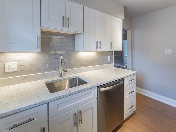 The Cary renovated kitchen with white cabinets, stainless steel appliances and a microwave