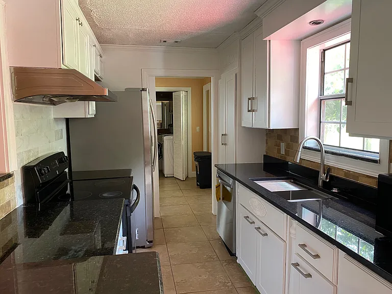 Well-equipped kitchen with ample cabinet space and convenient access to the dining area