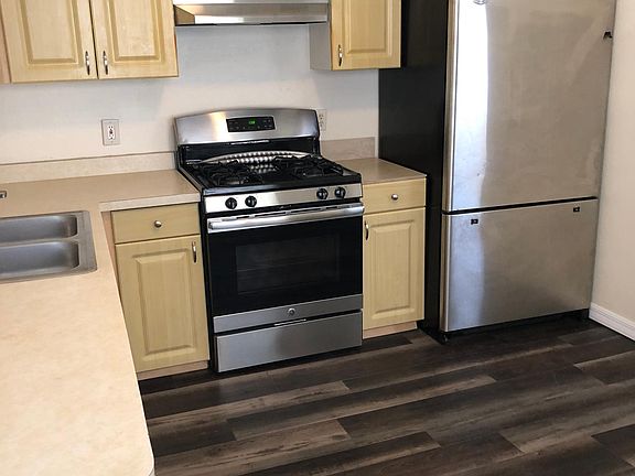Kitchen with dinette area has a brand new stove and large refrig