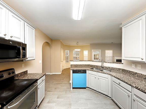 Kitchen - equipped with range, oven, refrigerator, microwave, garbage disposal, and dishwasher. Opens to breakfast area.