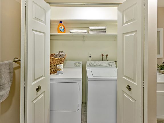 Spacious laundry closet with full-size appliances and built-in shelving at Haynes Run Apartments in Medford, NJ.