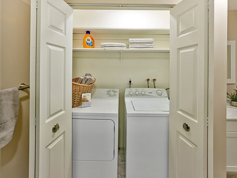 Spacious laundry closet with full-size appliances and built-in shelving at Haynes Run Apartments in Medford, NJ.