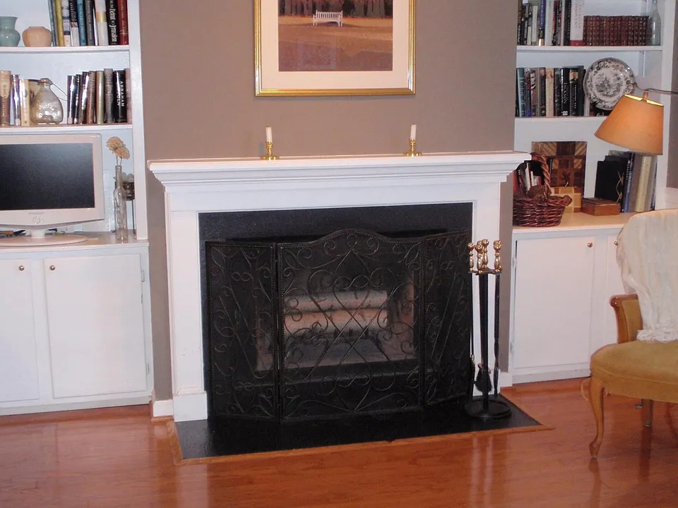 Den next to kitchen with working wood-burning fireplace.