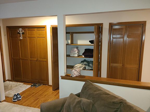 View of the entry way from the living room, with three closets visible.