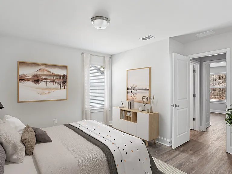 Secondary bedroom with queen bed, large sunlit window.