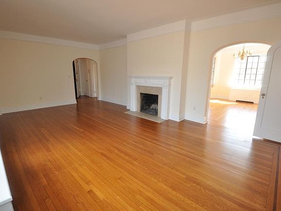 Large Living Room overlooks Garth Woods, has a working fireplace and refinished hardwood floors. Cove ceiling and arched doorways complete the look.