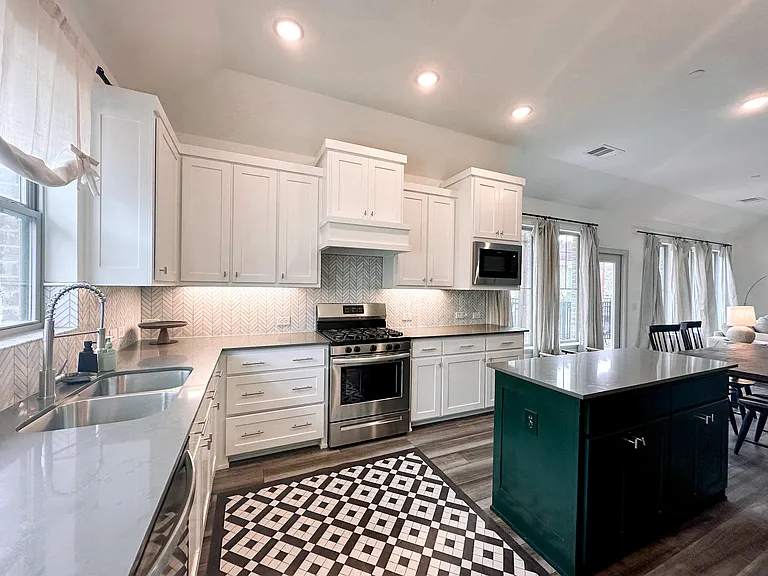 Light and open kitchen with tons of counter space with sink with a view