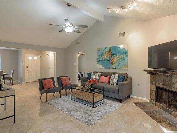 This spacious family room has tall ceilings, corner fireplace new ceiling fan.