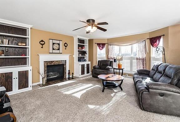 The living room offers a gas fireplace with flanking built-in bookcases and large bay window with custom plantation shutters.