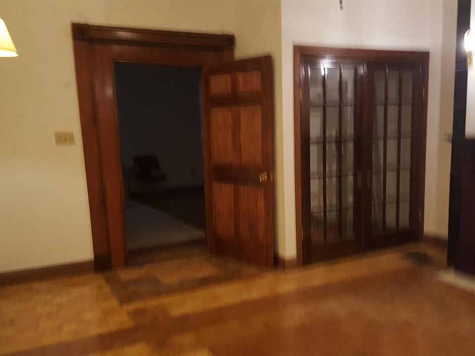 spacious bedroom, high ceilings, marble fireplace, with decorative carved wooden mantel piece.