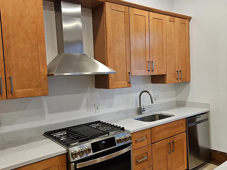 1st floor: kitchen range with stainless steel hood and vent.