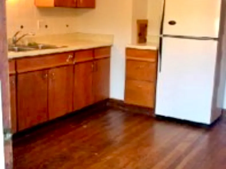 Large kitchen with banks of cabinets, deep pantry closet & small balcony overlooking back yard