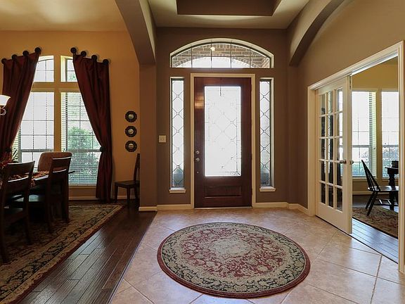 Another view of this spacious entryway. Formal dining and study both have beautiful rich hardwood flooring. Notice the obscured glass on the front door and side windows. This is a perfect solution to gain privacy while allowing for maximum natural li