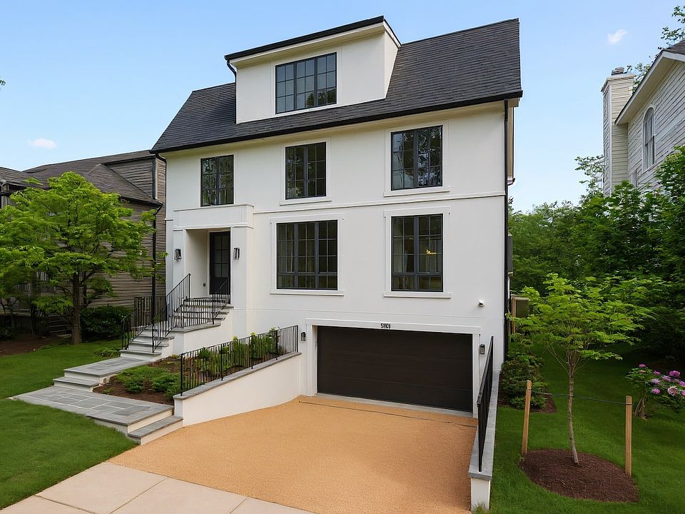 Entry raised, garage set below, glass climbs three floors