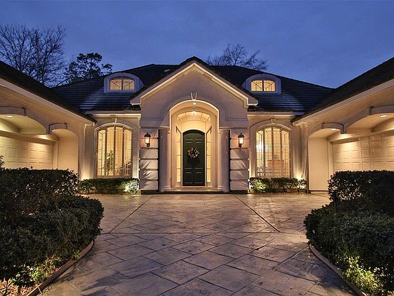 SENSATIONAL NIGHT ENTRY VIEW WITH UP-LIGHTING. Here is the view of the exterior front entry with 4 car garage and stamped concrete driveway. Breathtaking!